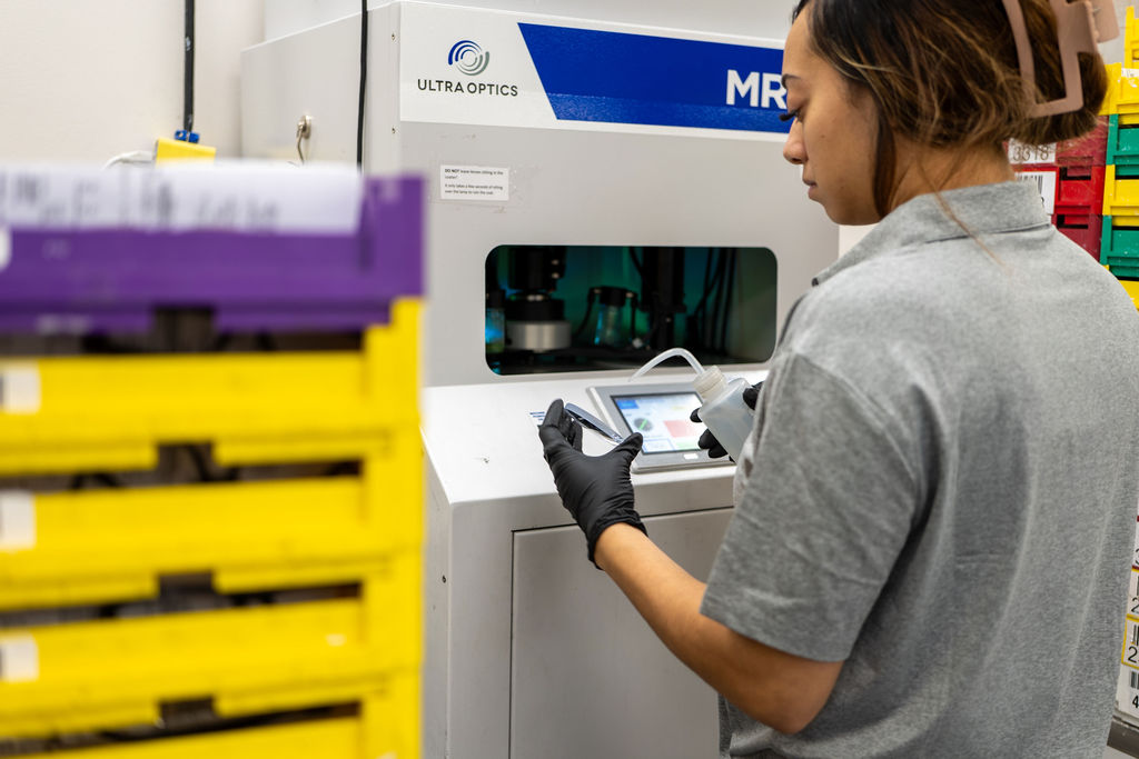 Technician operating an Ultra Optics AR coating machine