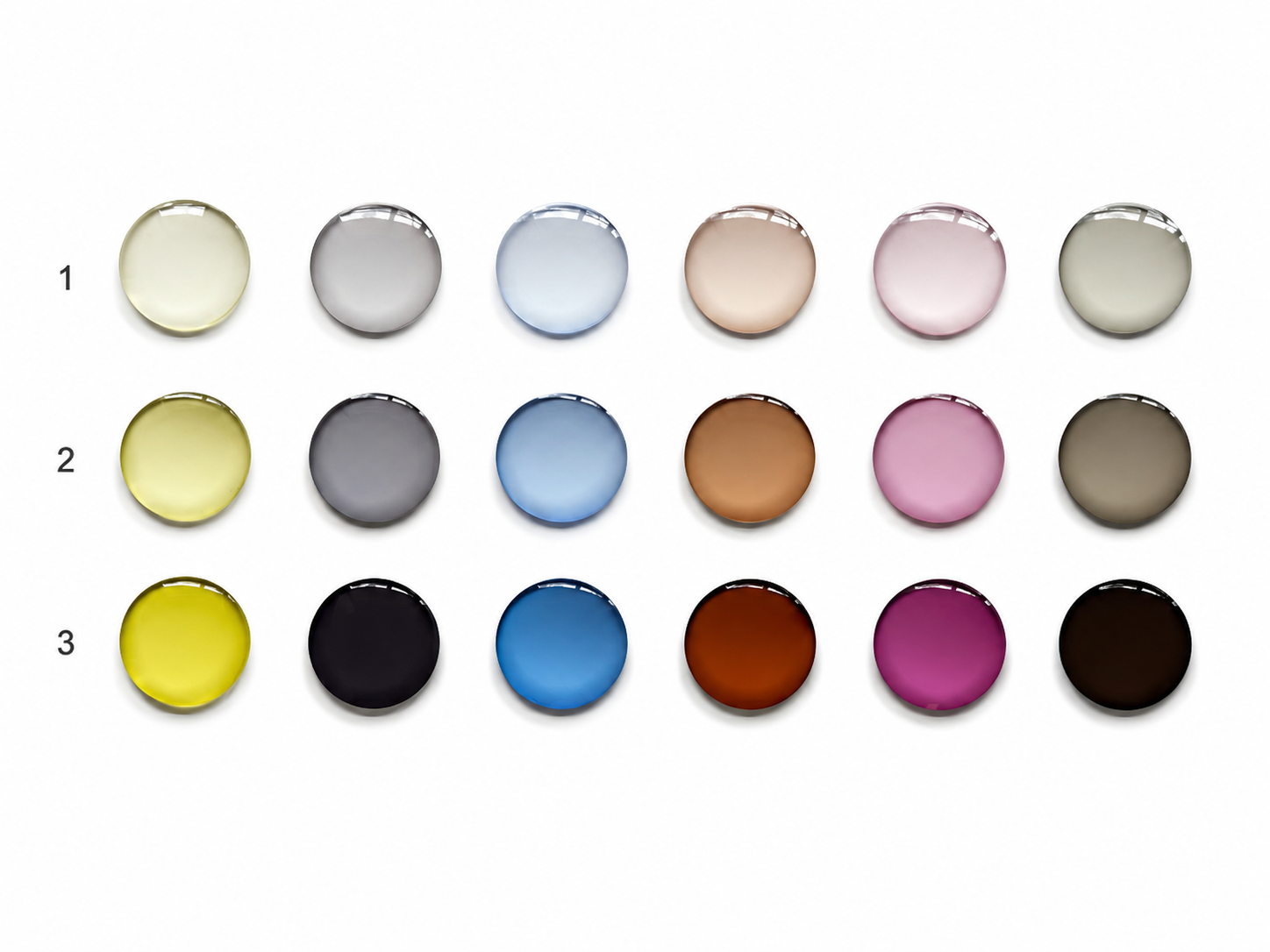 Top-down photo of tinted lens blanks in three rows labeled 1, 2, and 3, showing light, medium, and dark densities across yellow, gray, blue, brown, rose, and green