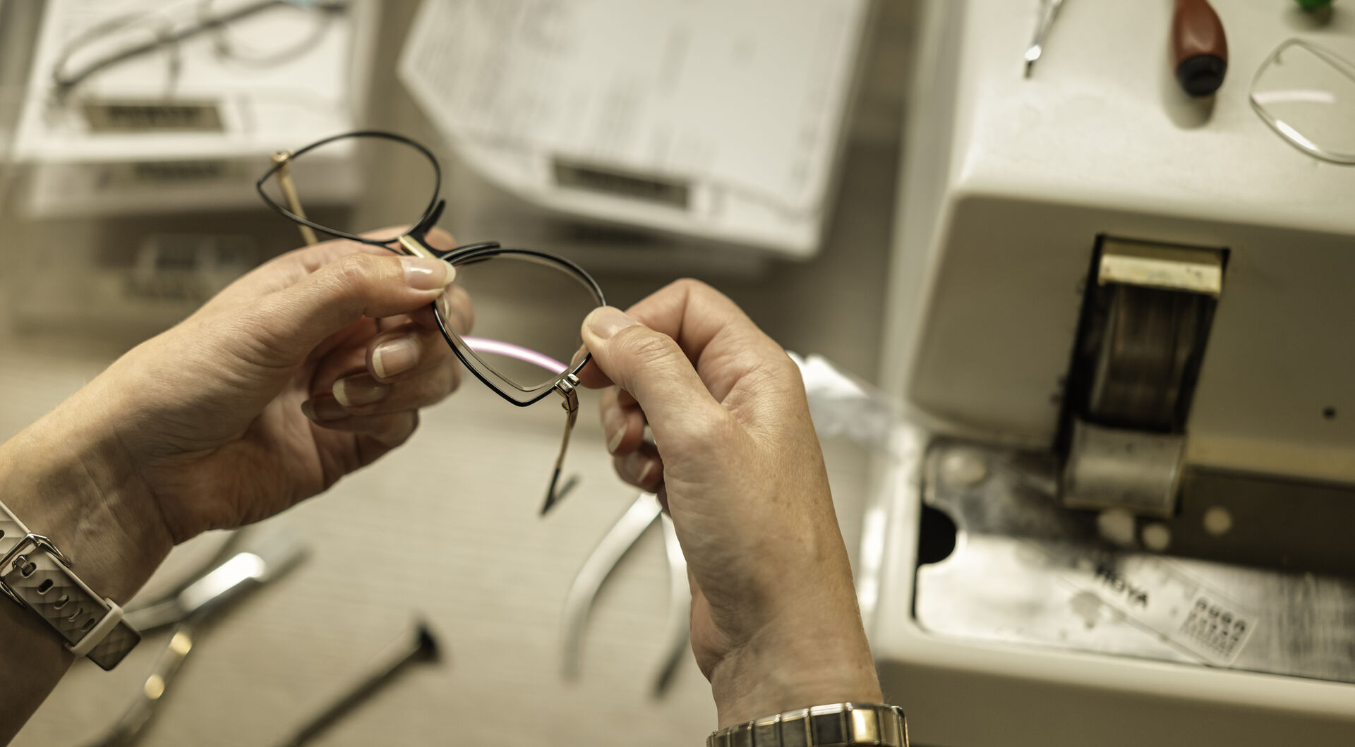 HOYA lens craftsmanship — hands at work in the lab